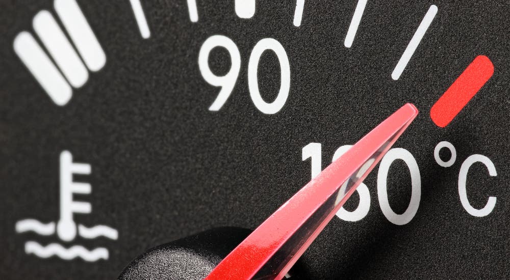 A closeup shows a temperature gauge with a red needle.