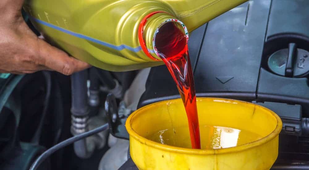 A mechanic is filling the transmission fluid after a transmission service.