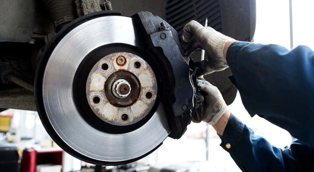 A closeup shows a mechanic removing the brake pads during a Kings Ford service.