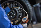 Mechanic checking a tire with a tire pressure sensor